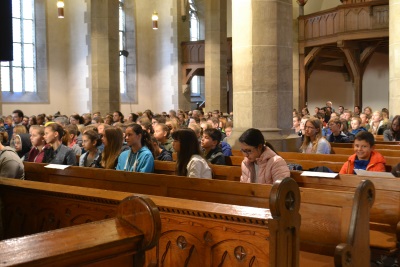 Anfangsgottesdienst in der Stiftskirche in Öhringen. Schülergruppen sitzen in den Bankreihen.