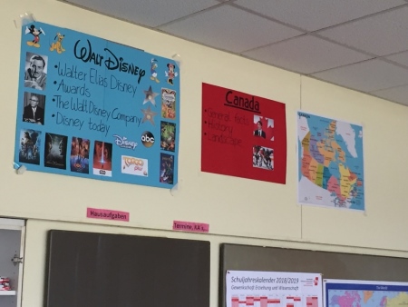 Foto von Plakaten in bilingualen Lehrerunterrichtszimmer. Linkes Plakat zeigt Bilder von Walt Disney mittleres Plakat zeigt Bilder von Kanada und rechtes Plakat zeigt die Staaten Kanadas.
