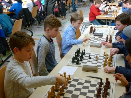 sechs SchÃ¼ler sitzen sich beim Schachturnier gegenÃ¼ber und spielen Schach