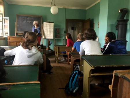SchÃ¼lergruppe in einem alten Klassenzimmer - wie war Schule frÃ¼her. Lehrerin steht am Pult