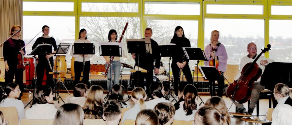 Musikerinnen und Musiker des SWR-Symphonieorchesters mit ihren Instrumenten auf der Bühne im Musiksaal der Realschule Öhringen